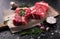 Two raw fresh marbled meat black angus steak ribeye, garlic, salt