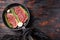 Two raw picanha organic  beef steaks ready for grill on pan with herbs and garlic. Over old dark wooden background, top view with