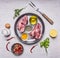 Two raw pork steaks in the pan with lemon, butter, pepper, salt and herbs wooden rustic background top view