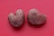 Two raw potatoes in the shape of a heart on a red background. Potato love story. history 2. Pink potatoes isolated on a