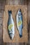 Two raw seabass fish with slice of lemon on wooden background