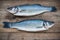 Two raw seabass fish on wooden background
