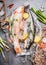 Two raw whole fish with fresh ingredients for tasty and healthy cooking. Gold Rainbow trout on concrete stone background with ice