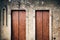 Two rectangular medieval doors in grey stone wall.