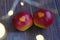 Two red apples with a heart seal on the table. Orange heart on organically grown fruits. Growing fruits with prints.