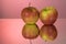 Two red apples on mirroring table on mirror red background with reflection isolated close up