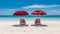 Two red beach chairs and umbrellas on a beautiful white sand beach in front of the ocean on sunny day
