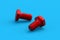 Two red bolts on blue background. Construction materials. Industrial equipment. Tools in the workshop.