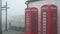 Two red British telephone booths in a fog