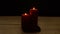Two red candles burn and roses in romantic time on wood table