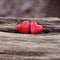 Two red ceramic hearts on wooden background with copy space