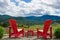 Two red chairs overlooking vineyard