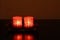 Two red chinese decorative candles in darkness.