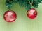 Two red christmas decoration on the branch of artificial christmas