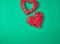 Two red decorative heart braided from a rod