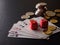 Two red dice, game cards and stack of coins