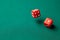 Two red dice on green poker gaming table in casino. Concept online gambling. Copy space for text