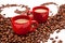 Two red espresso cups with coffee beans