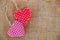 Two red fabric hearts on rustic canvas