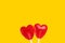 Two red fruits lollipop heart shape candies on bright yellow background. Romantic Valentines love concept