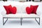 two red heart cushions on white snowcovered outdoor loveseat