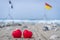 Two red hearts on the beach with surf flags in the background