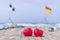 Two red hearts on the beach with surf flags in the background