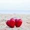 Two red hearts on the beach symbolizing love