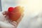 Two red hearts in a hand on a palm. Light background, sunny flare. The concept of love. Valentine`s Day