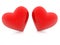 Two red hearts lean against each other