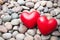 Two red hearts on pebble stones