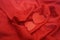 Two red hearts on red silk background with ripples