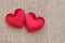 Two red hearts symbol of love on sackcloth