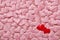 Two red hearts on valentine background from pink silk hearts. Valentine`s Day. Top view with copy space. Hearts background