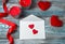 Two red hearts on a white envelope on a romantic background.