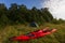 Two red kayaks in the grass