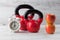 Two red kettlebells with apples, and clock