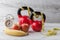 Two red kettlebells with measuring tape, apples, banana, and clock