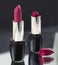 Two red lipsticks, perfect versus imperfect symbolic concept ide