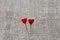 Two red little hearts on the background of linen