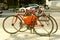 Two red locked old road bikes with drop handlebars on circle metal bicycle rack