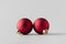 Two red matte Christmas balls on a seamless grey background