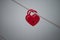 two red padlocks in shaped heart on metallic cable in border water