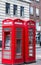 Two red phone booths on the street at the center part of the city.. London