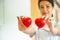 Two Red Smiling Hearts held by smiling female nurse`s hands, representing giving effort high quality service mind to patient.