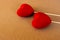 Two red velvet hearts on a natural brown paperboard surface. St. Valentine`s day greetings postcard. Lover`s day. Love backgroun