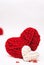Two red and white clews in shape of heart made from yarn