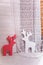 Two red and white styrofoam reindeer toys on wooden and lace fabric background. Christmas decorative elements. New Year and winter