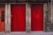 Two red wooden doors soft filtered. Closed red door at the street in old town. Vintage facade. Ancient exterior of building.