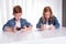 Two redhaired kids are playing with their smartphones